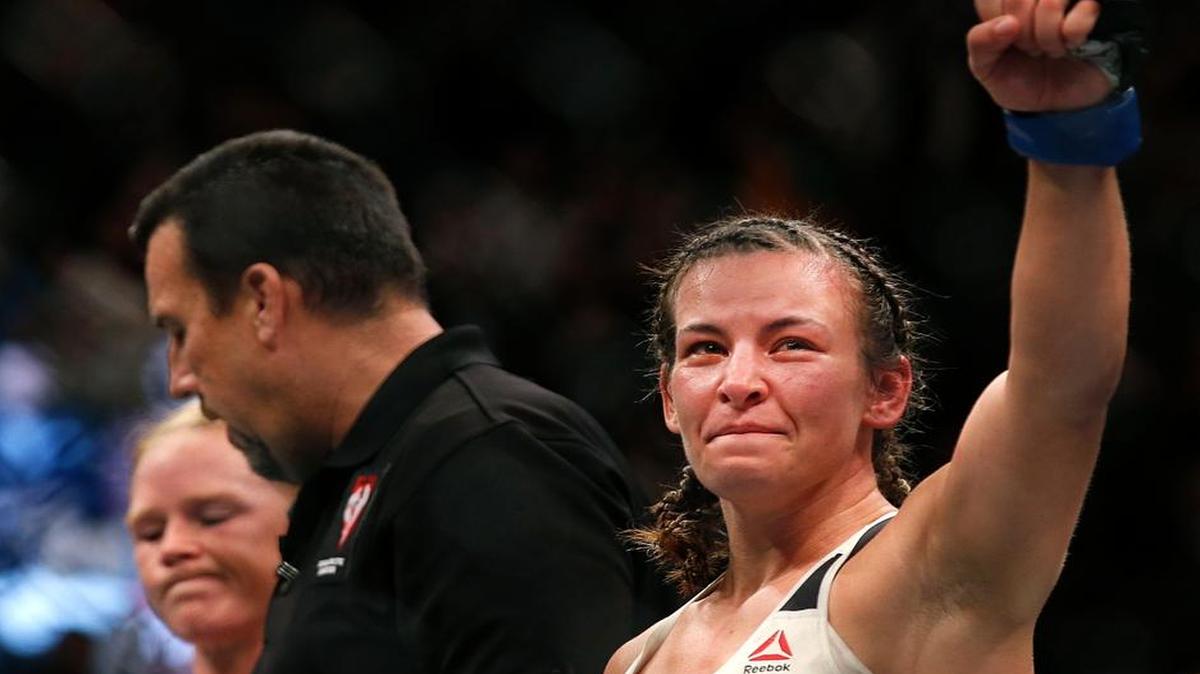 Miesha Tate, right, celebrates her victory over Holly Holm just after their UFC 196 women’s bantamweight mixed martial arts title match, Saturday, March 5, 2016, in Las Vegas. Tate won by fifth round submission. (AP Photo/Eric Jamison)