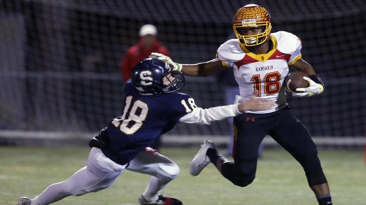 Kamiakin High School’s Darreon Moore, right, evades Southridge’s Logan Grigg (18) during Thursday night’s Mid-Columbia Conference game at Lampson Stadium in Kennewick. The Braves won 50-10.