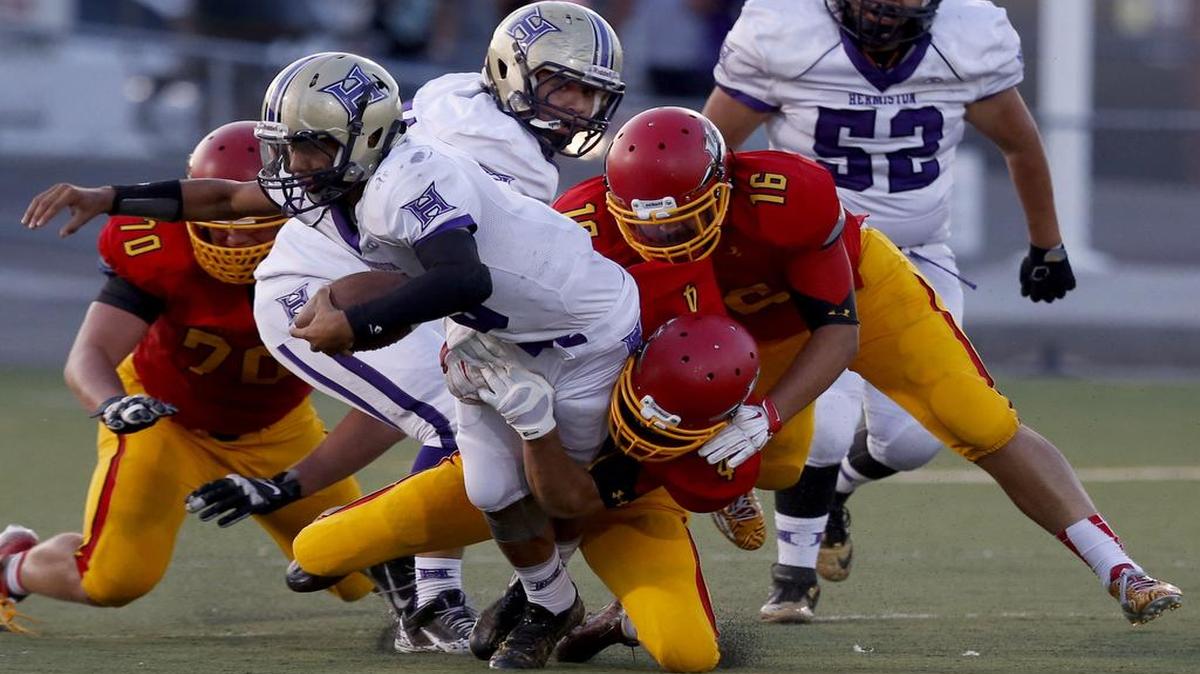 Kamiakin High School's Alex Bayuk (4) and Mike Jones (16) tackle Hermiston High School's Dayshawn Neal (5) Sept. 11, 2015 at Neil F. Lampson Stadium in Kennewick. If Hermiston is allowed to join the WIAA, Kamiakin — and the rest of the MCC — would gain an extra Class 3A conference opponent.