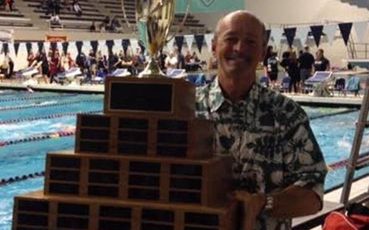Randy Willis, holding the Class 4A girls state swim trophy after the Richland Bombers claimed a share of the 2014 team title, has stepped down after more than two decades coaching the Richland and Hanford girls.