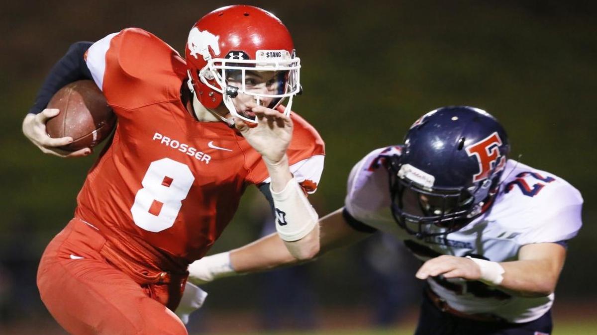 Prosser quarterback Tanner Bolt runs around an Ellensburg defender last season. The football powerhouses will renew their rivalry Friday, with the inside track to the conference title on the line.