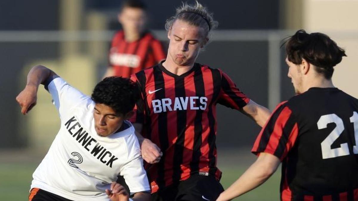 Kamiakin’s Andrew Scrimsher, middle, and Kaleb Rinsberry (21) steal a ball from Kennewick’s Armando Ponce during Tuesday’s Mid-Columbia Conference soccer match at Lampson Stadium. See more photos at www.tricityherald.com.