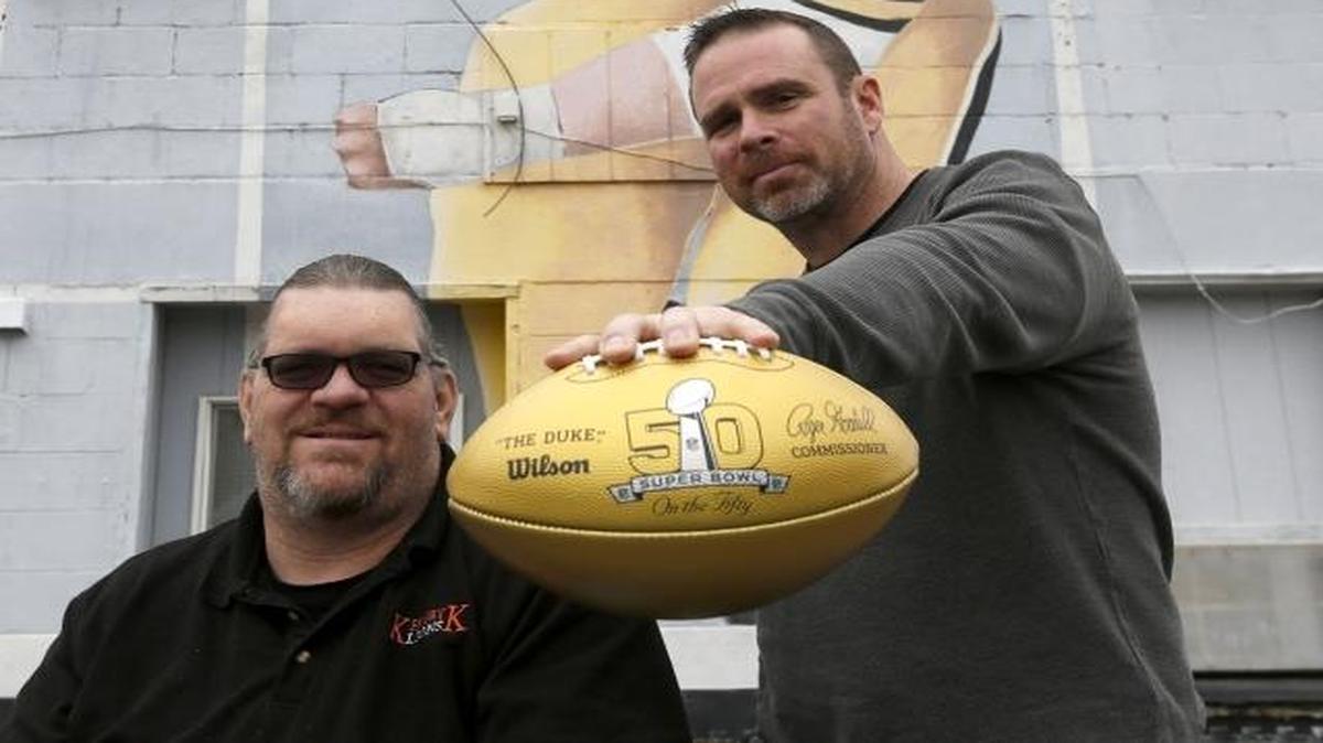 Kennewick High School athletic director Ronny Coleman, left, and football coach Bill Templeton pose with a golden Wilson NFL football at the Ray Mansfield mural in downtown Kennewick. The NFL sent out more than 3,000 golden balls to schools from which a player or coach who participated in a Super Bowl graduated. Kennewick High School graduate Mansfield was a two-time Super Bowl champion with the Pittsburgh Steelers. See a video at www.tricityherald.com.