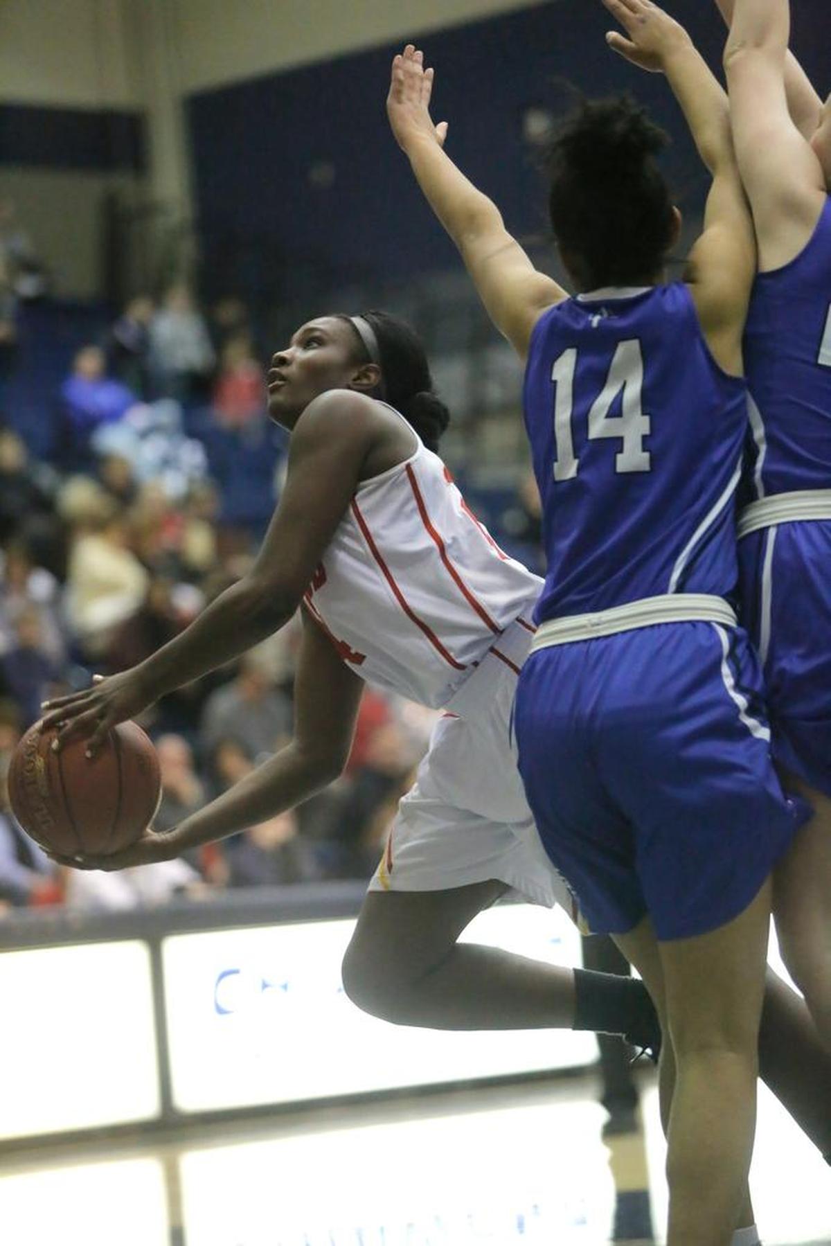 Kamiakin’s Oumou Toure (24) stretches to get a layup around Seattle Prep’s Tamia Stricklin (14) during a Class 3A state regional game Friday at Kamiakin High School in Kennewick. The Braves beat the visiting Panthers 73-57.