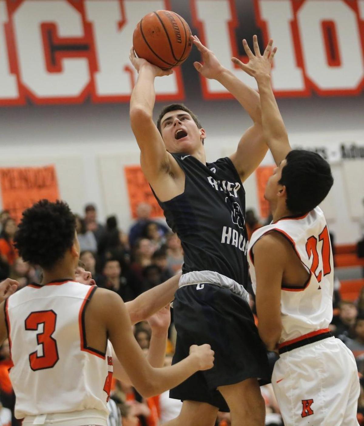 Chiawana’s Seth Schmidt (13) takes a shot over Kennewick's Ayoni Benavidez (3 and Omar Hernadez (21) during Mid-Columbia Conference boys basketball game Friday Kennewick. Schmidt scored 16 points and had three blocks in Chiawana’s 63-56 victory.