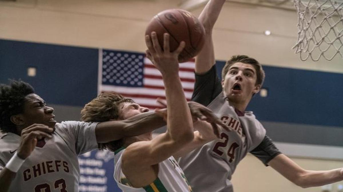 Richland’s Cole Northrop takes on a double team of Moses Lake’s Gio Walker (23) and Ryan Karsetter (24) during Friday’s Class 4A boys regional at Chiawana High School.