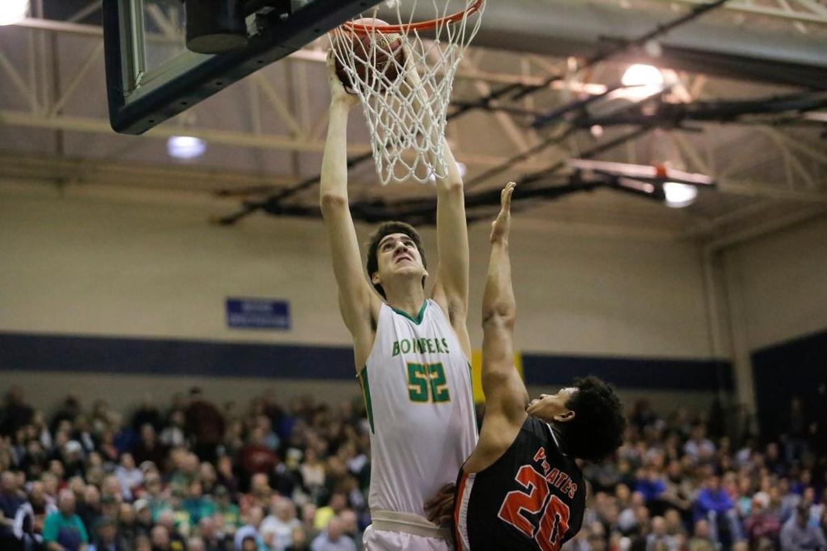 Richland’s Riley Sorn (52) dunks over Davis’ Ivory Kimble-Evans during their WIAA 4A regional boys basketball playoff Friday at Chiawana High School in Pasco. Richland won 86-61.