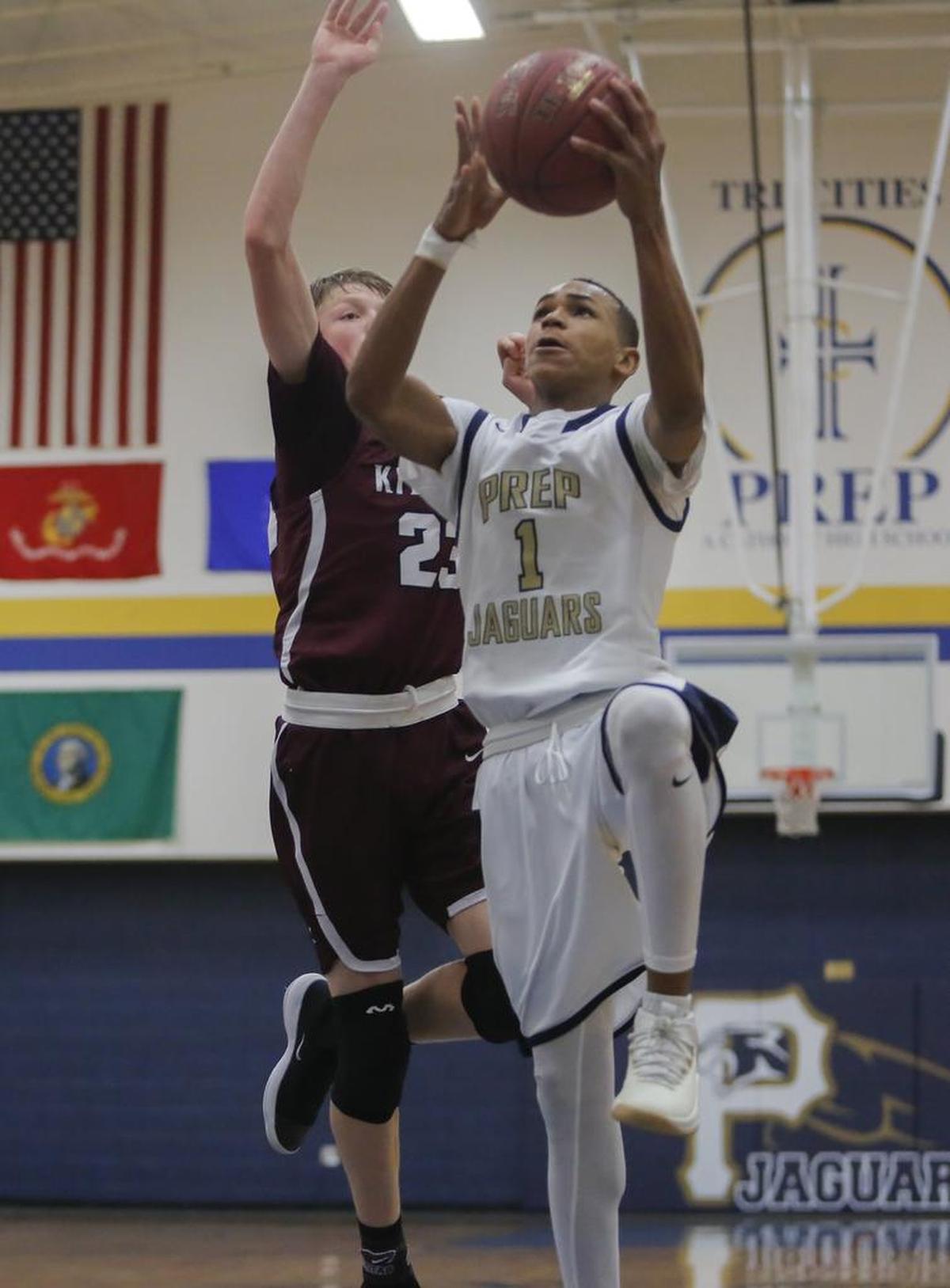 Tri-Cities Prep’s Kobe Singleton (1) shoots a layup while being defended by Kittitas/Thorp’s Mason Landdeck (23) during an EWAC boys basketball game Friday at Tri-Cities Prep in Pasco. Singleton led the Jaguars with 23 points in the 68-60 loss.