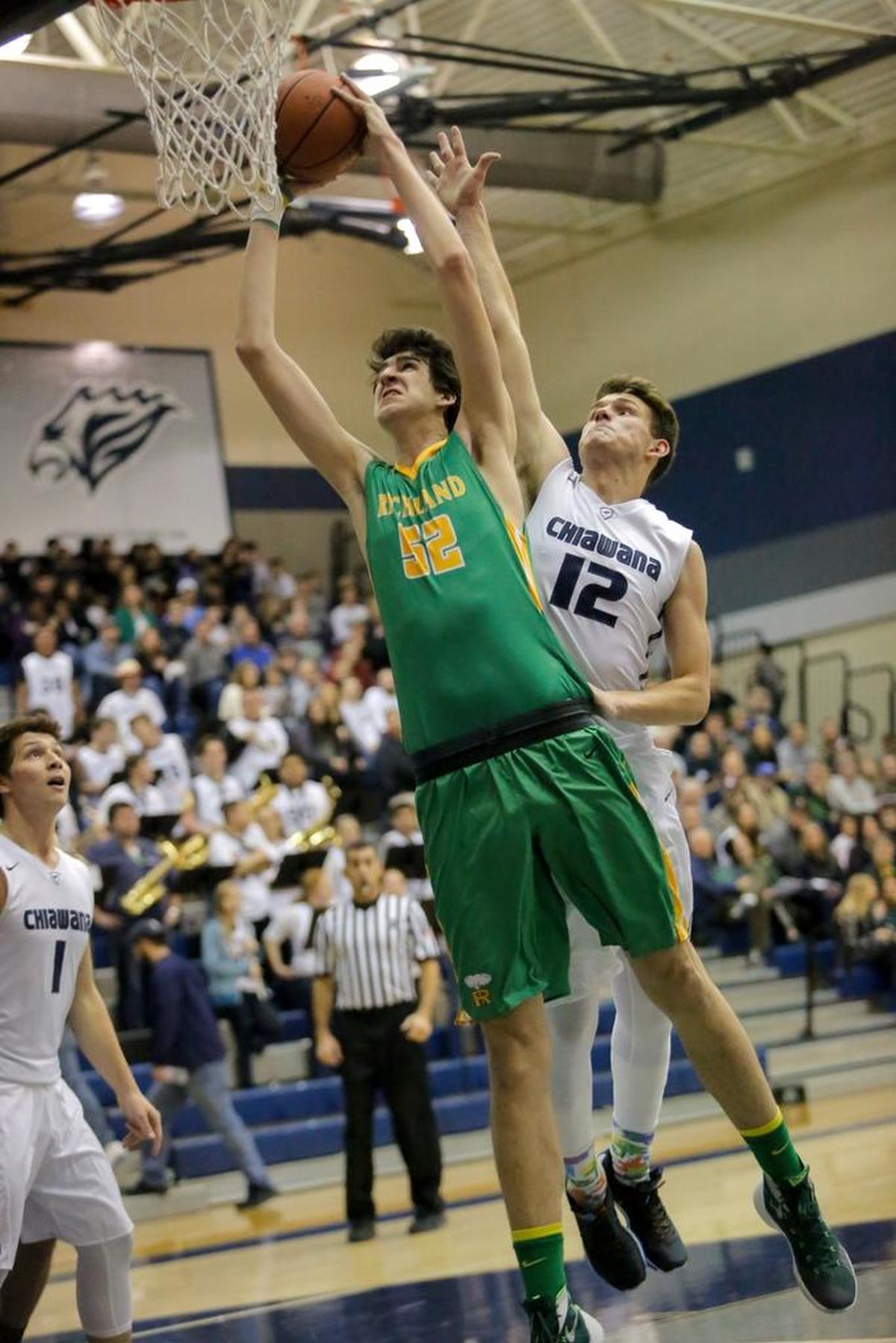 Richland's Riley Sorn dunks the ball as Chiawana's (12) attempts to block his shot during a Mid-Columbia Conference boys basketball game Friday at Chiawana High School in Pasco.