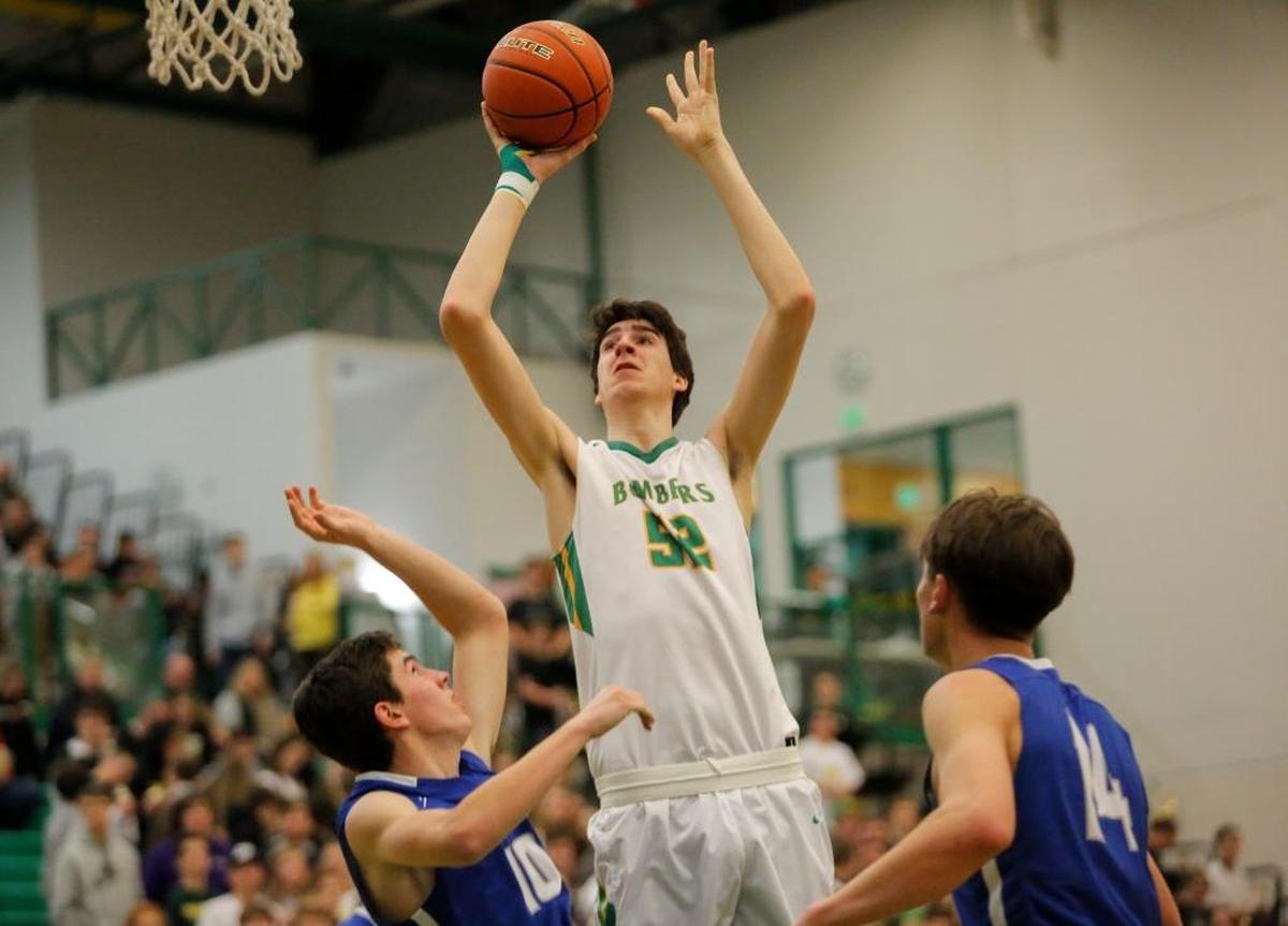 Richland’s Riley Sorn (52) skies over Walla Walla defenders Scott Golden (10) and Taylor Hamada (14) during an MCC boys basketball game Friday at Richland High School.