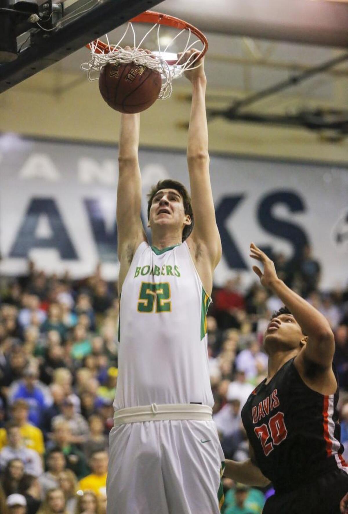 Richland’s Riley Sorn (52) dunks the ball as Davis’ Ivory Kimble (20) looks on during their regional playoff game played Feb. 24, 2018 at Chiawana High School in Pasco.