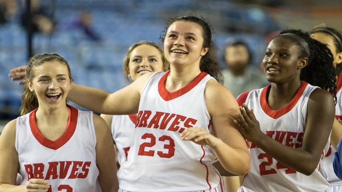 Kamiakin’s Chanceler Williams, middle, and teammates Salee Westermeyer, left, and Oumou Toure, right, were all smiles after Williams sank the game-winning bucket in overtime Saturday at the Class 3A state basketball tournament in Tacoma. The Braves won in overtime to finish fourth.