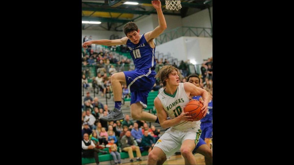Walla Walla’s Scott Golden (10), left, jumps to block Richland’s Cody Sanderson (10) as he tries to shoot the ball during a boys basketball game Friday at Richland High School. Led by Sanderson’s 23 points, the Bombers beat the Blue Devils 74-50.