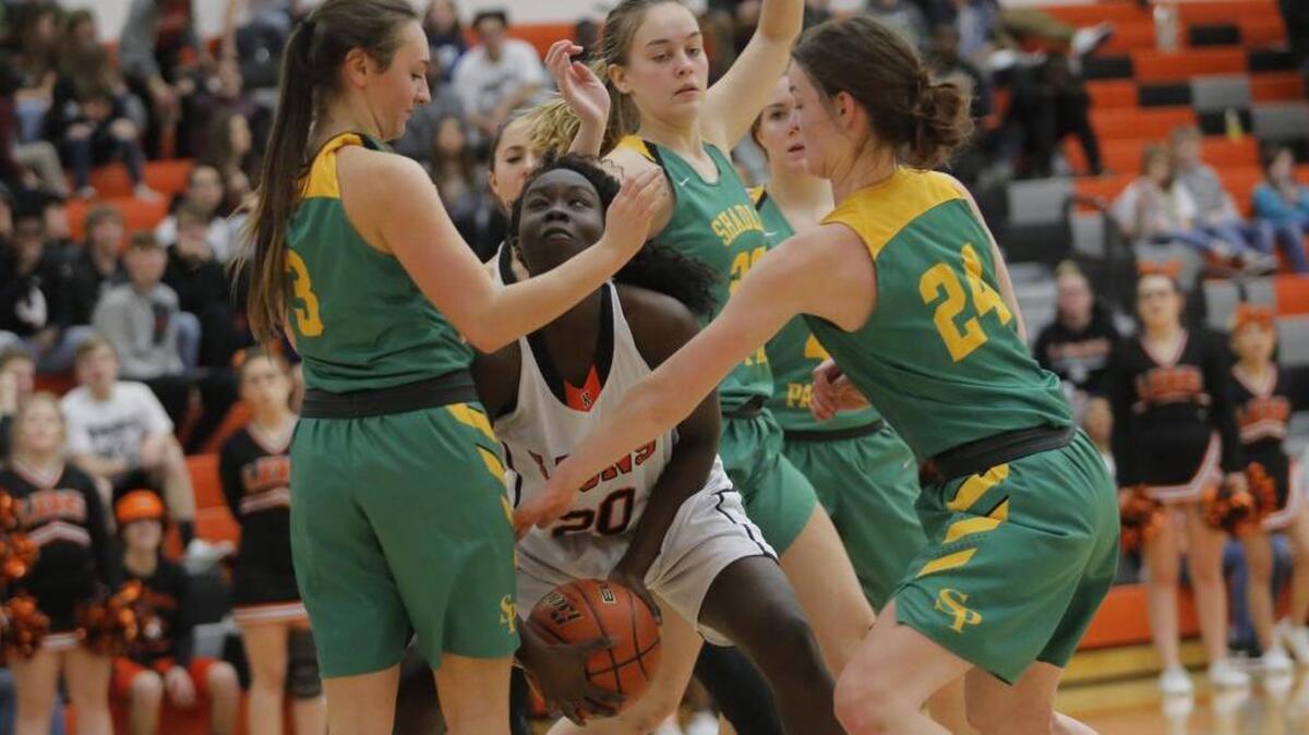 Shadle Park’s defense surrounds Kennewick’s Nyaruach Guich as she tries to take a shot during a District 8 3A girls basketball playoff game on Tuesday at Kennewick High School. The Lions won 59-36.