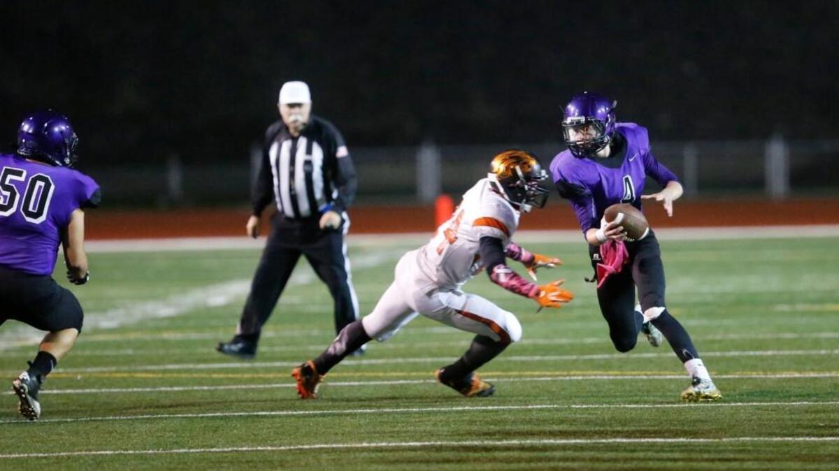 Pasco quarterback Keaton Stewart (right) tries to elude a Kennewick defender during their game last season. With Stewart graduating, the quarterback duties fall to senior Kashon Tate.