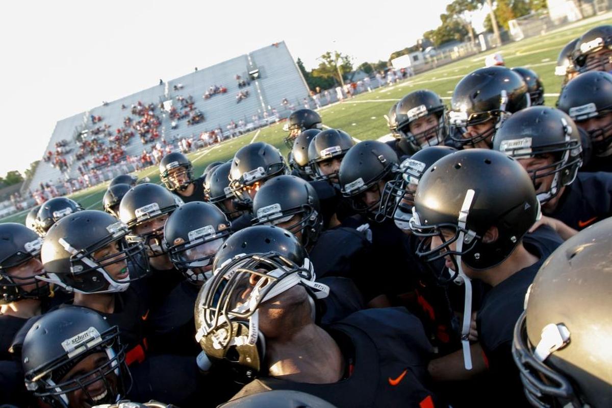 Moses McAninch (bottom, center) fires up the Kennewick High School football team before the start of the season opener against Prosser at Lampson Stadium.