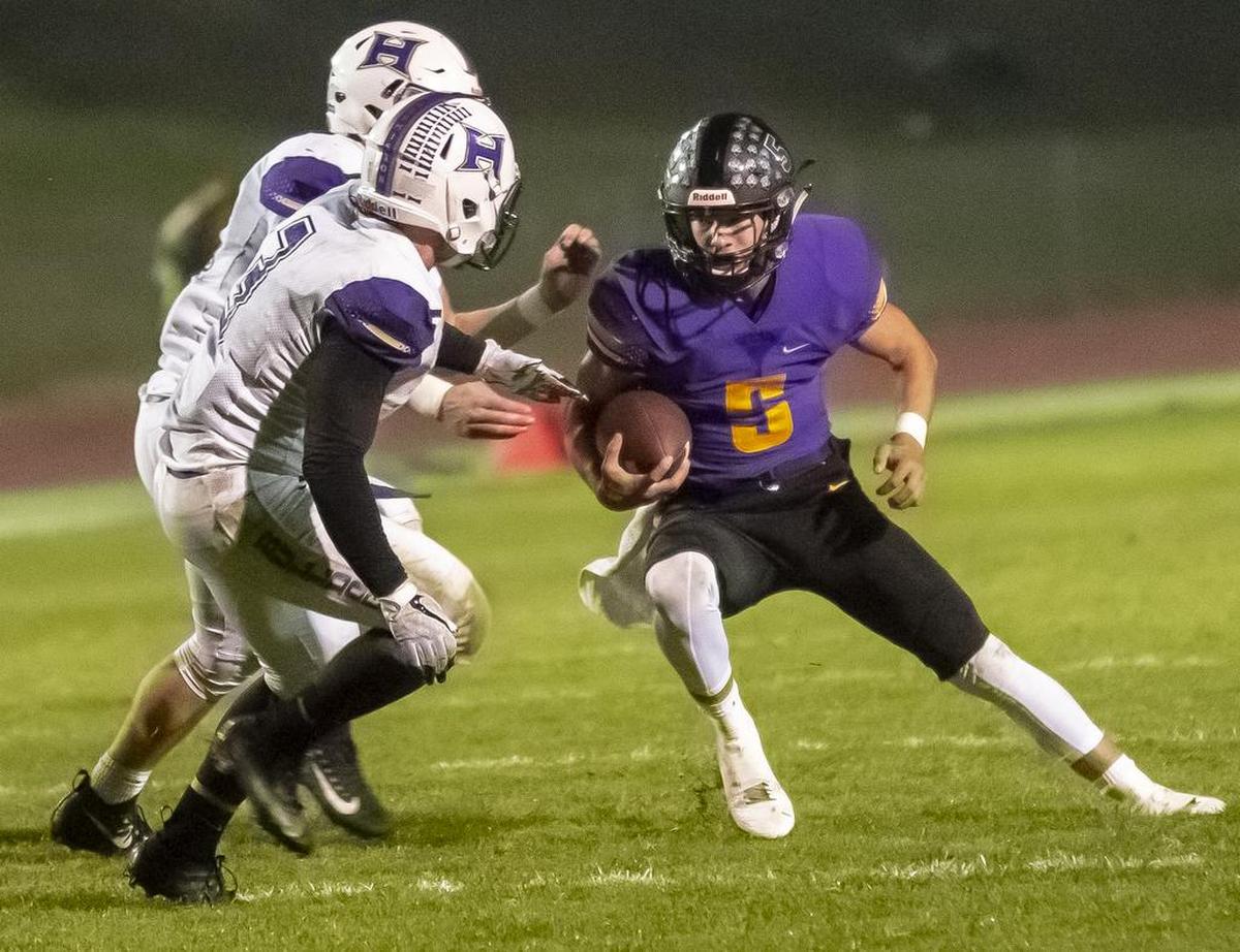 Hermiston defenders Wyatt Noland, back, and Cash Campbell (3) attempt to take down Hanford’s Garrett Horner (5) as he runs with the ball during a Mid-Columbia Confrence high school football game at Fran Rish Stadium in Richland on Friday. Hermiston won in O.T. 42-35.