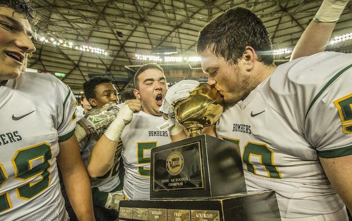 Richland lineman Jacobe Lee (50) kisses the trophy as the Bombers celebrate winning the WIAA 4A State Football Championship Dec. 2 in the Tacoma Dome. Lee is an All-Area first team defensive lineman.