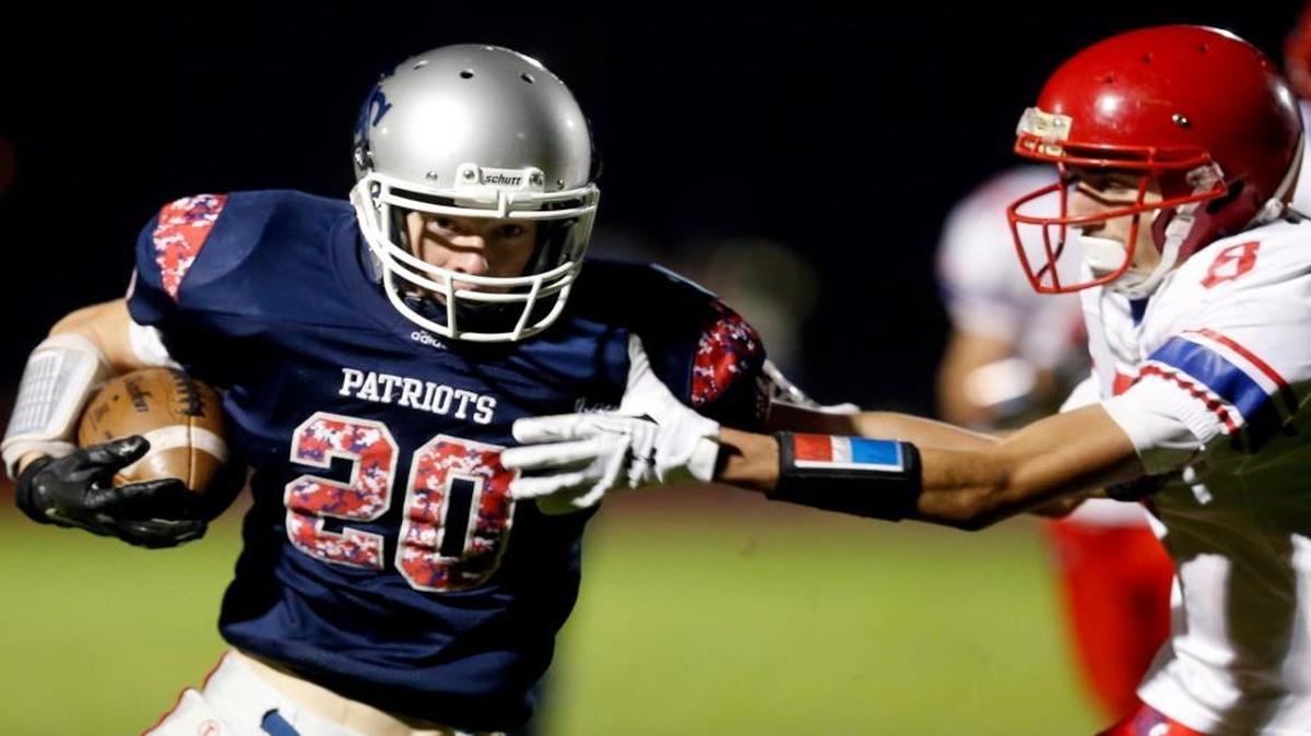 Liberty Christian’s Nico Shupe (20) stiff-arms his way past Touchet tackler Carlos Rincon (8)during Thursday’s game at Hanford High School. See more photos at www.tricityherald.com.