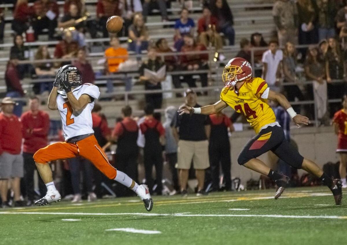 Kennewick receiver Talon LaFontaine (2) has an eye on the ball and a couple steps on Kamiakin defensive back Devyn Koonhuntod (24) during the Lions’ 21-19 win over the Braves on Friday night at Lampson Stadium.