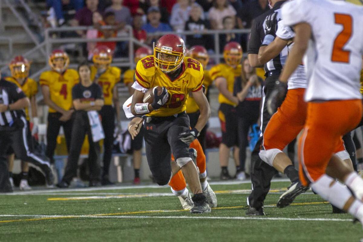 Kamiakin’s Ray Chavez (28) looks for open space running against the Kennewick defense.