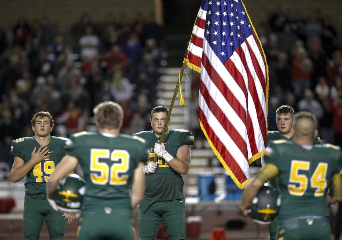 The Richland Bombers take the field for the National Anthem on Friday before the start of a Mid-Columbia Conference football game against Kamiakin at Fran Rish Stadium in Richland.