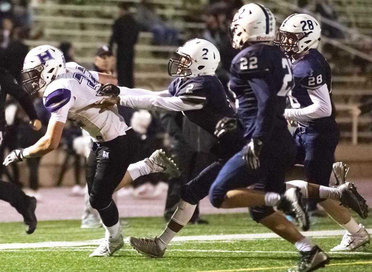 Hermiston’s Jordan Ramirez (33) attempts to breakaway from Chiawana’s Dion Lee (2) as he runs with the ball during a Mid-Columbia Conference high school football game at Edgar Brown Stadium in Pasco on Friday. Chiawana won 34-10.