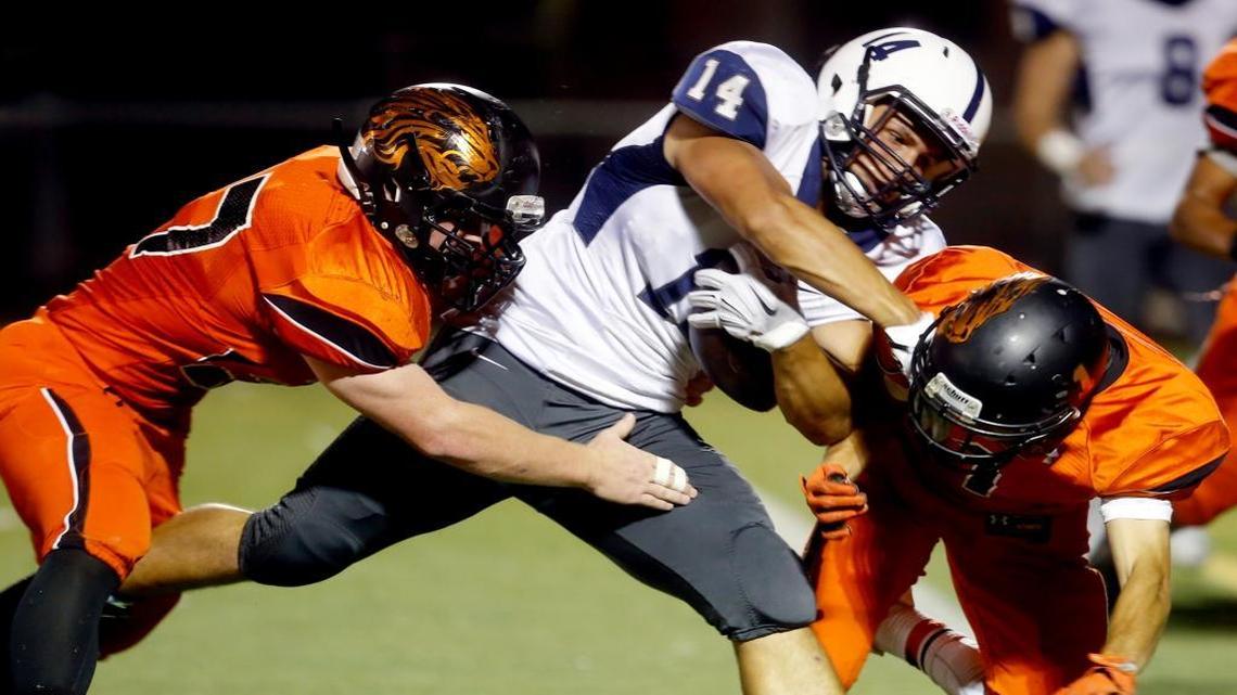 Chiawana High School’s Andrew Vargas (14) pushes past Kennewick High School’s Blake Loftus, right, and Andrew Fridley to score a touchdown Thursday during a Mid-Columbia Conference game at Neil F. Lampson Stadium in Kennewick. See more photos at www.tricityherald.com.