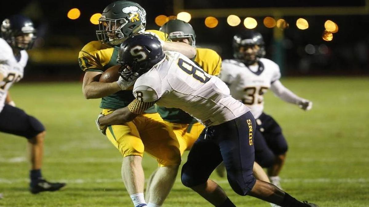 Richland’s Parker McCary (21) looks to get away from Southridge’s Brycen Kelly on Friday night at Fran Rish Stadium.