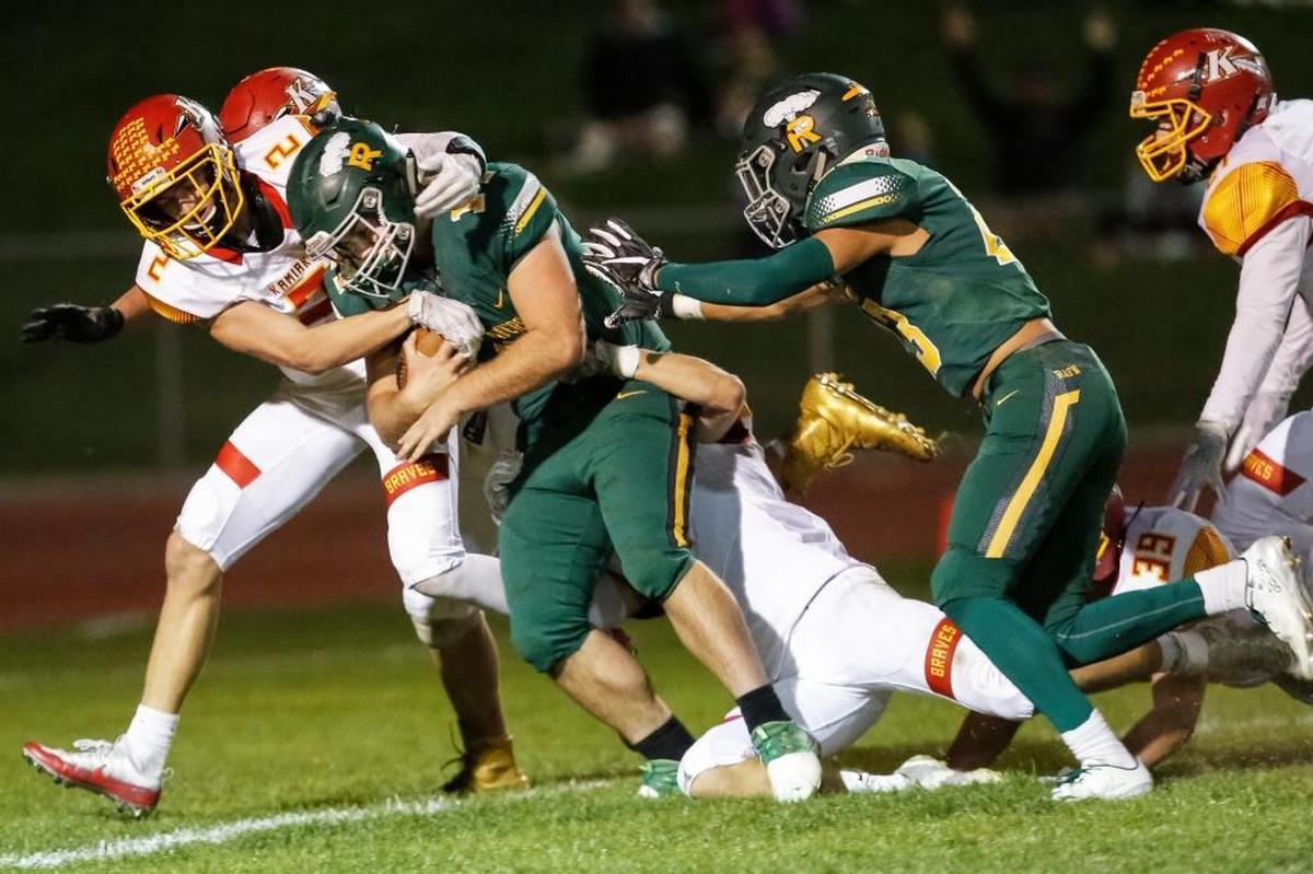 Richland running back Jared Whitby (14) runs 44 yards, dragging Kamiakin’s defense while scoring a touchdown during a Mid-Columbia Conference high school football game on Friday at Fran Rish Stadium in Richland. The Bombers beat the Braves 33-0.
