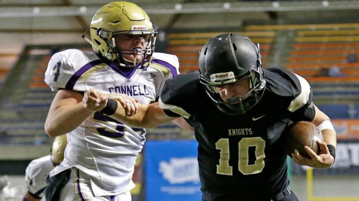 Royal quarterback Kaden Jenks (10) scores against Connell defensive end Ben Brock, left, during Saturday’s Class 1A state title game at the Tacoma Dome.