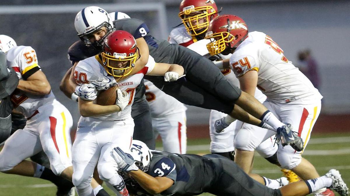 Chiawana’s Anthony Liudahl (9) soars through the air while his defensive teammate, Anthony Cabrera (34), stays low to take down Kamiakin runner Jethro Questad (20) during Friday night’s game at Edgar Brown Stadium in Pasco. The game ended after press time. The story is posted at tricityherald.com/sports.