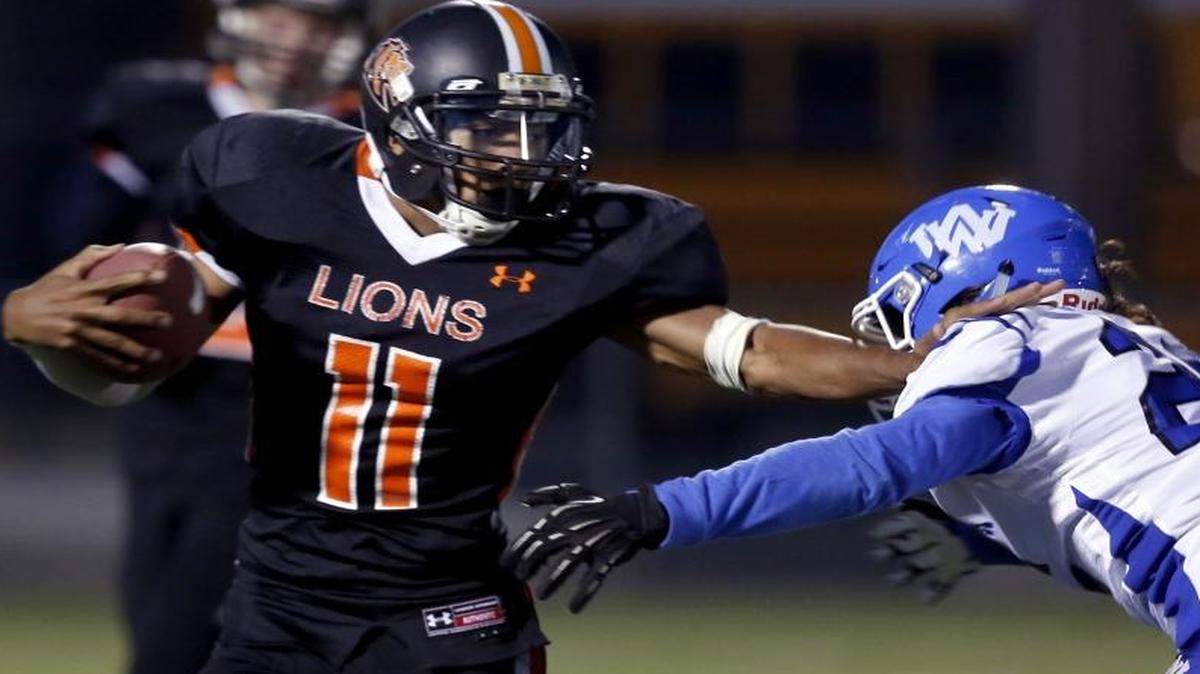 
Kennewick High School running back Ronnie Loomis (11) pushes past Walla Walla defender Sam Hoe on Thursday night at Lampson Stadium in the Mid-Columbia Conference opener for both teams.
