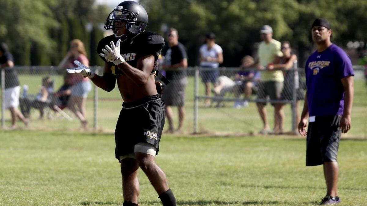 Hanford High School’s Tayvonne Miller catches a pass as coaches and spectators watch Saturday’s practice. Miller is the returning leader in receiving and rushing for the Falcons, who are entering their first season as a Class 4A program.