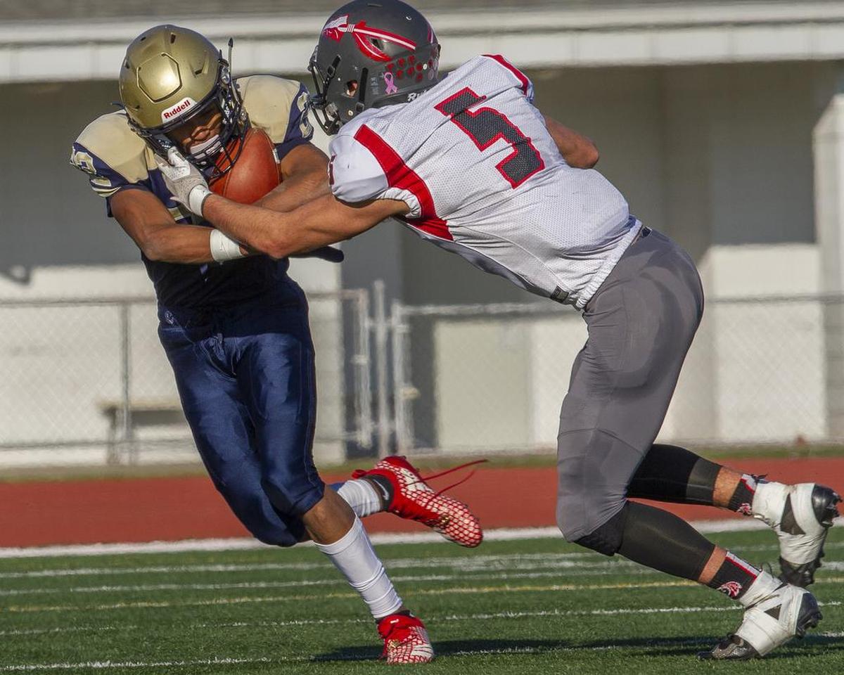 Tri-Cities Prep’s Kobe Singleton (22) carries the ball as Toledo’s Fano Arceo-Hansen (5) tries to stop him during playoff game on Saturday, Nov. 17, at Edgar Brown Stadium in Pasco. Toledo won 34-23.