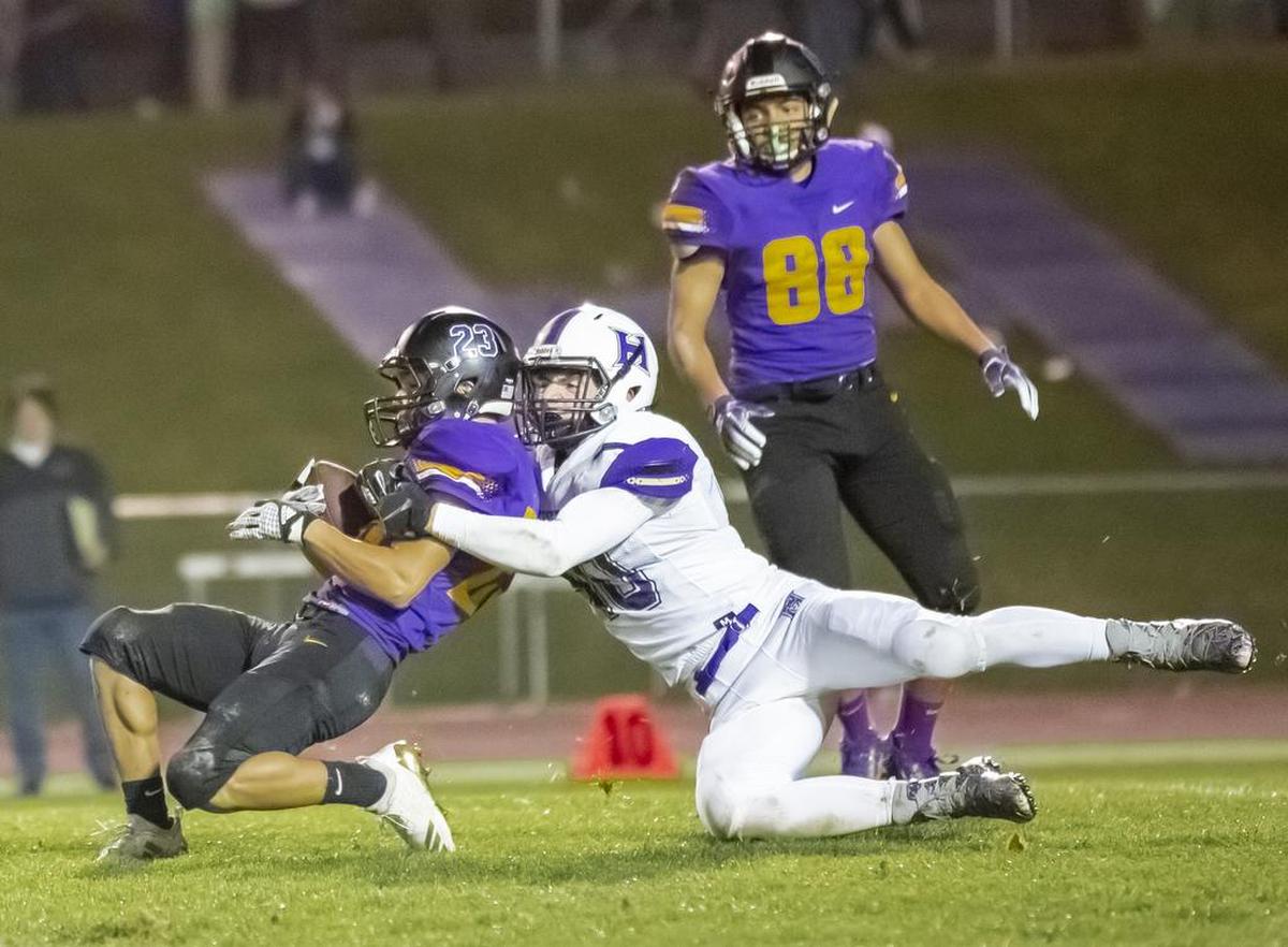 Hanford’s Gabe Martinez (23) is tackled by Hermiston’s Zane Davis (40) during a Mid-Columbia Confrence high school football game at Fran Rish Stadium in Richland on Friday. Hermiston won in 42-35 in OT.