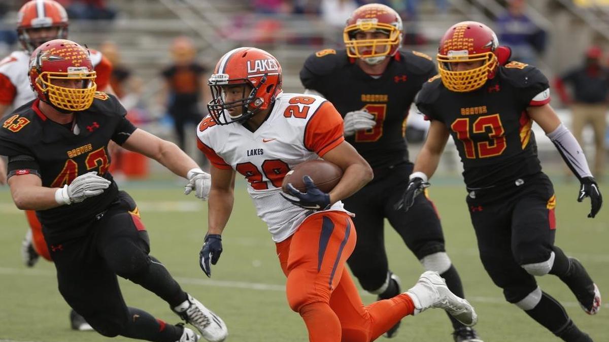 Kamiakin defenders Austin Crawford (43), Logan Smith (8), and Brandon Searls (13) try to surround Lakes running bak Yisrael Stephens during Saturday’s state playoff game at Lampson Stadium.