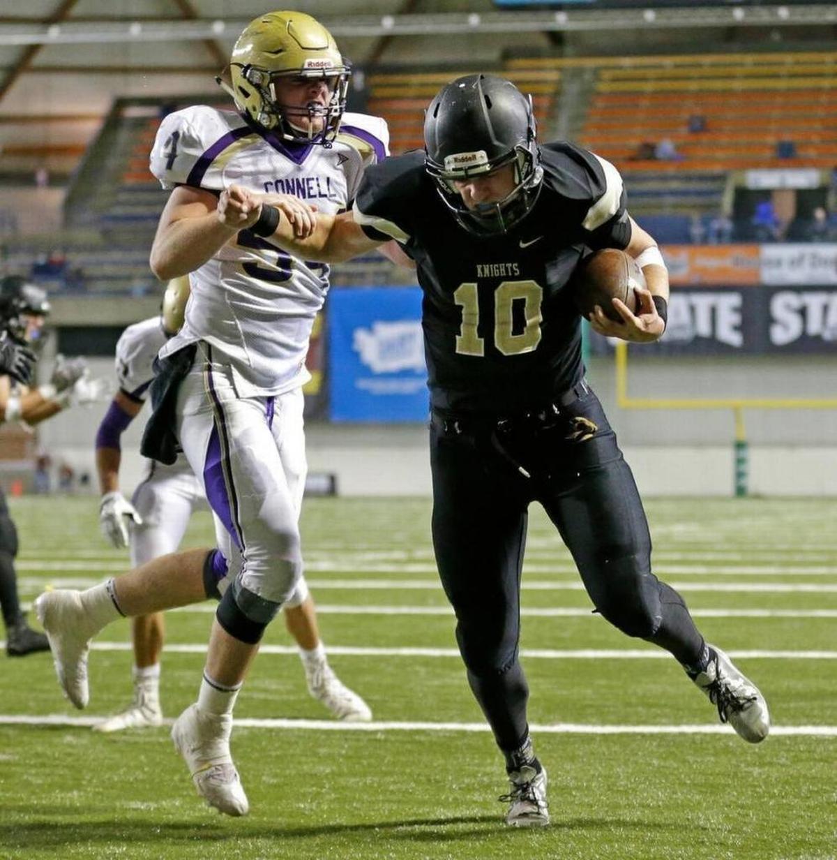 Royal quarterback Kaden Jenks (10) scores against Connell defensive end Ben Brock, left, during the 2016 Class 1A state championship football game at the Tacoma Dome.