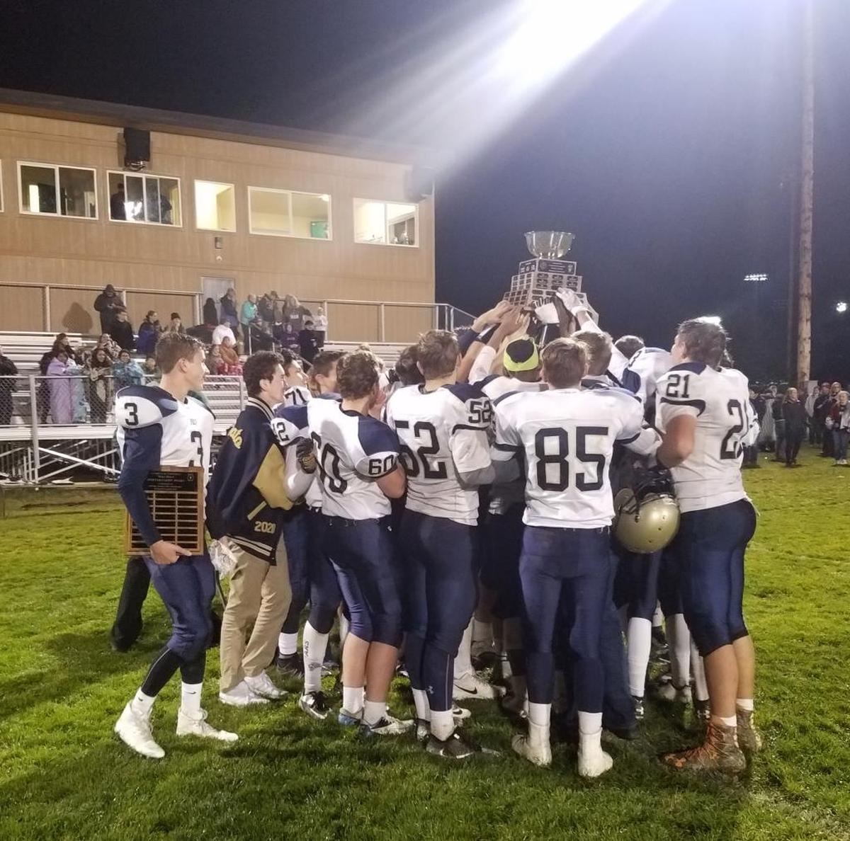 The Tri-Cities Prep football team lofts the trophy after defeating DeSales 26-7 in the annual Holy Bowl between the Catholic schools.