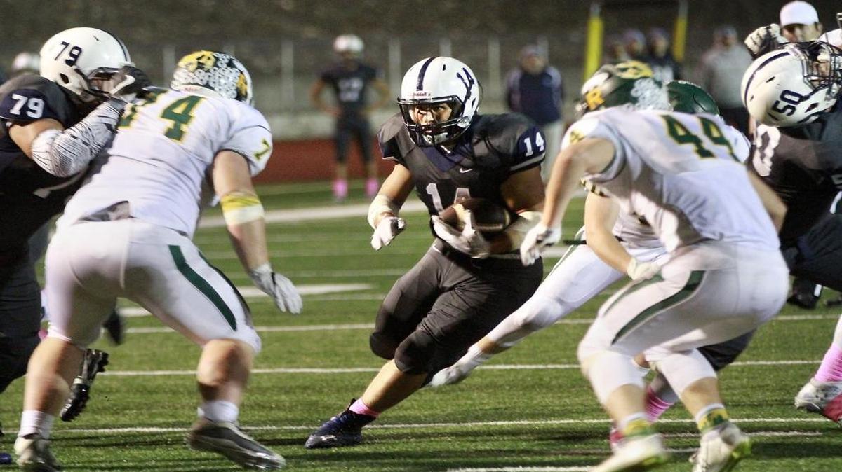 Chiawana running back Andrew Vargas (14) looks for an opening behind the blocking of his teammate Joey Aikala during Friday night’s game against the Richland Bombers in Pasco. Richland defenders Brigham Whitby (74) and Victor Strasser (44) close in on the the play near the goal line.