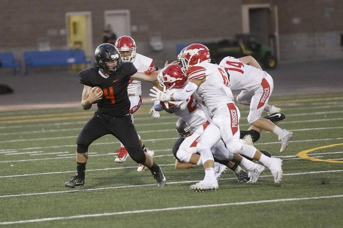 Kennewick running back Atticus Templeton (4) stiff arms a Prosser defender on Friday at Lampson Stadium. Prosser defeated Kennewick 22-14.