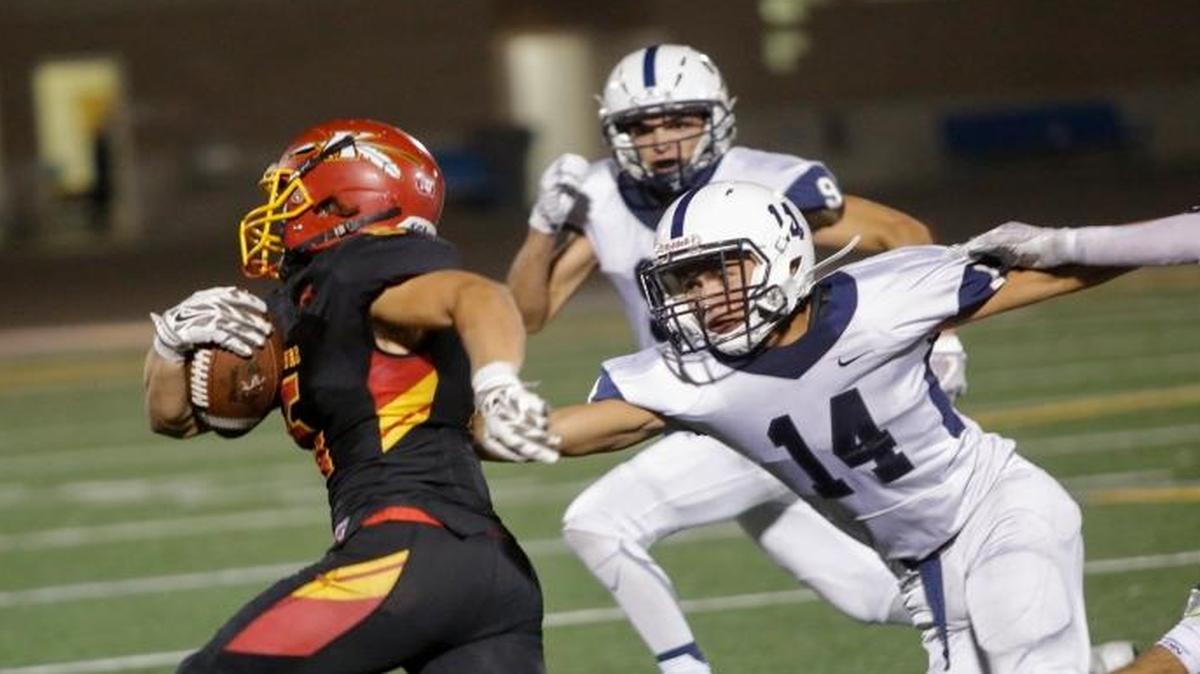 Kamiakin running back Talmage Jacobson, left, runs past Chiawana’s Jose Cruz (14) during their game Sept. 15 at Lampson Stadium. The Braves are ranked No. 3 in the Class 3A poll for the third consecutive week.