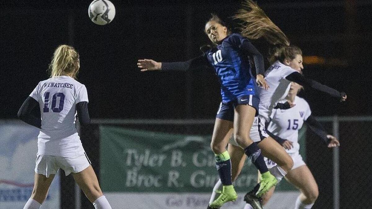 Chiawana’s Summer Yates (10, in blue) jumps to head a ball during a WIAA Class 4A state playoff game against Wenatchee on Tuesday at the Apple Bowl. The Panthers won 1-0, putting an end to the Riverhawks’ season. See a gallery from the game here.