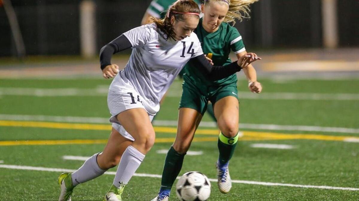 Kamiakin's Izzy Conover (14) tries to stay in control of the ball while being pressured by a Richalnd soccer player during a Mid-Columbia Conference girls soccer game at Lampson Stadium in Kennewick on Thursday.