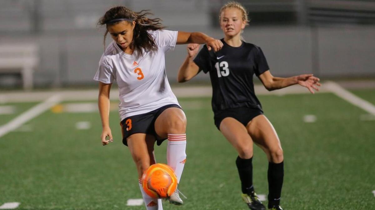 Kennewick’s Andrea Martell (3) traps the ball in front of a Rogers defender during a District 5/8 3A play-in soccer game Tuesday at Lampson Stadium in Kennewick on Tuesday. The Lions won 2-0.