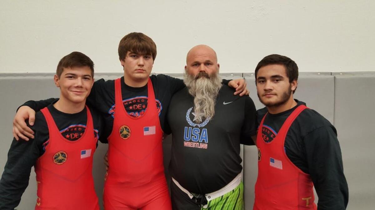Travis Ayers of Kennewick (second from right) has worked with wrestlers Austin Almaguer (from left), Jacob Olson and Sione Halo at the Tri-City Wrestling Club since they were in grade school.