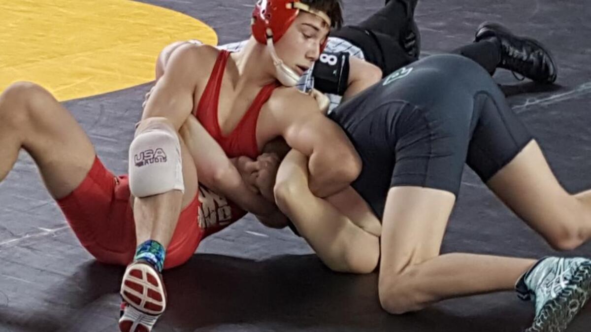 Kamiakin’s Austin Almaguer, left, has Riley Wynn of Peninsula tied up in their 120-pound first-round match at Mat Classic in Tacoma. Almaguer advanced with a 16-0 win.