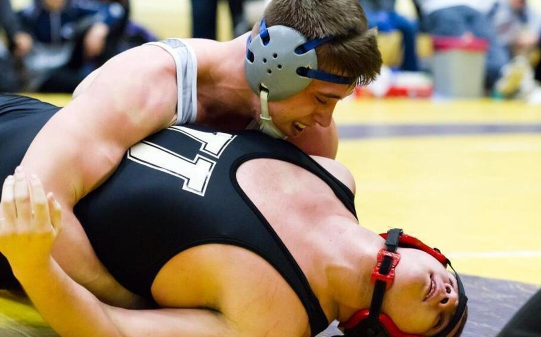 Chiawana’s Clayton Silvers (top) puts Caleb Thomas of University on his back in the third round of the 195-pound championship match of the 4A regional tournament Saturday at Hanford High School. Silvers rallied to win 8-7.