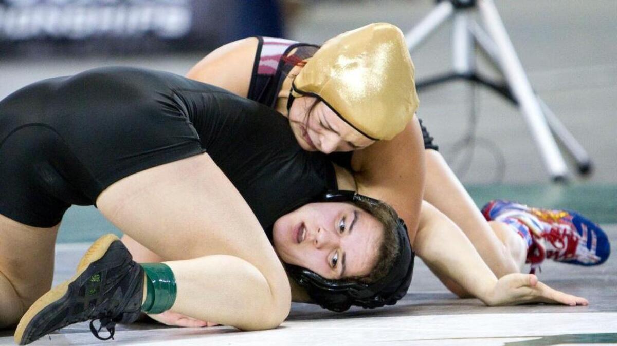 Grandview’s Desiree Zavala, above, works to flip Kamiak’s Ally De La Cruz during their 145-pound title match at the state wrestling championships Saturday in Tacoma. Zavala won by pin to earn her fourth state championship.