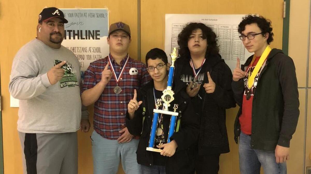 (From left to right) Othello’s Robert Pruneda (coach), Saul Mendoza, Oscar Ruiz, Noe Vargas and Edgar Mora pose with their hardware after winning the reserve bracket at the state chess championships on Saturday at Inglemoore High School in Seattle.